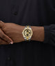 Gold and silver watch on a person's wrist against a black background