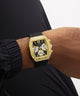 Gold GUESS Mens Black Gold Tone Analog Watch with black strap on a wrist against a neutral background