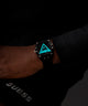 Watch with a glowing face on a wrist, brand 'Guess' visible