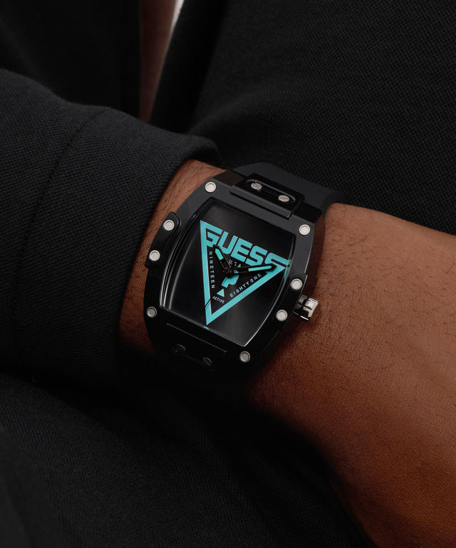 Black Guess watch on a wrist with a dark background