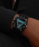 Black Guess watch on a wrist with a dark background
