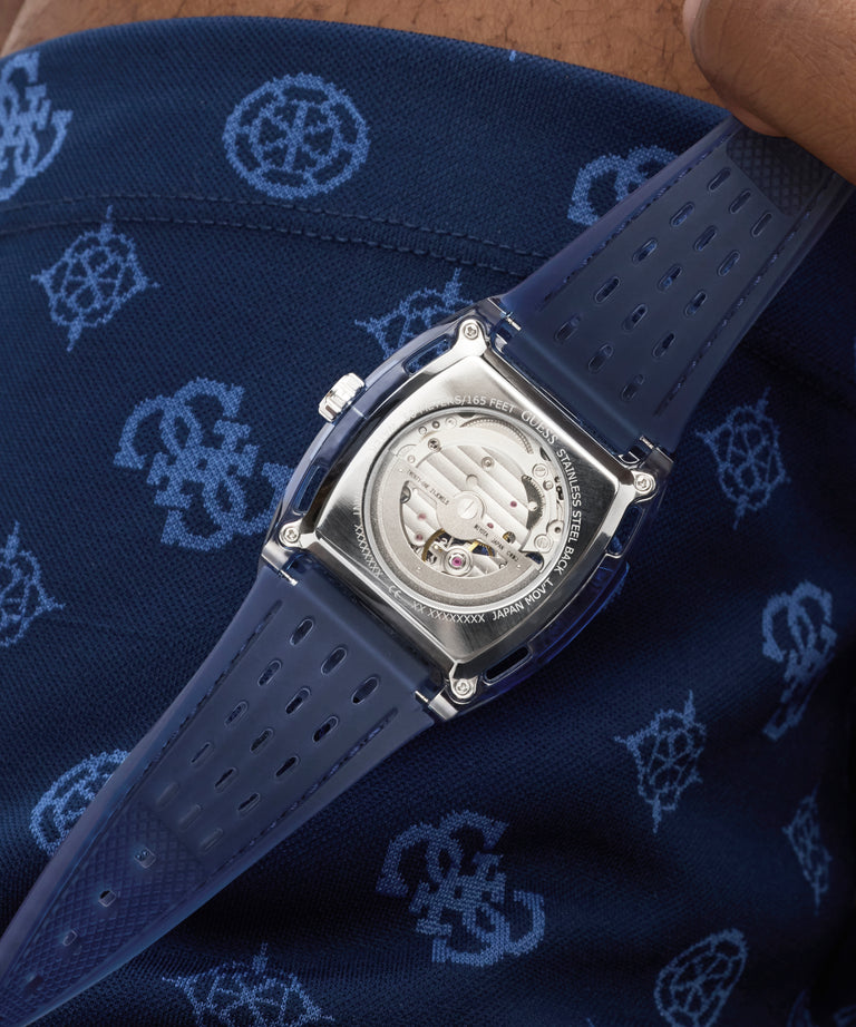 GUESS Mens Blue Analog Watch with a detailed face on a blue patterned fabric background