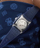 GUESS Mens Blue Analog Watch with a detailed face on a blue patterned fabric background