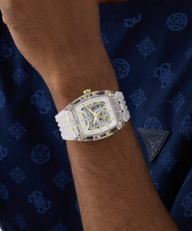 Silver watch with yellow accents on a wrist against a blue patterned background