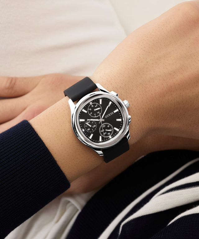 Black GUESS Mens Palmer Black Silver Tone Analog Watch with silver case on a wrist against a neutral background