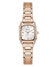 A GUESS women's watch featuring a rose gold-tone metal bracelet, a bezel set with clear crystals, and a white dial with gold-tone hands and hour markers.