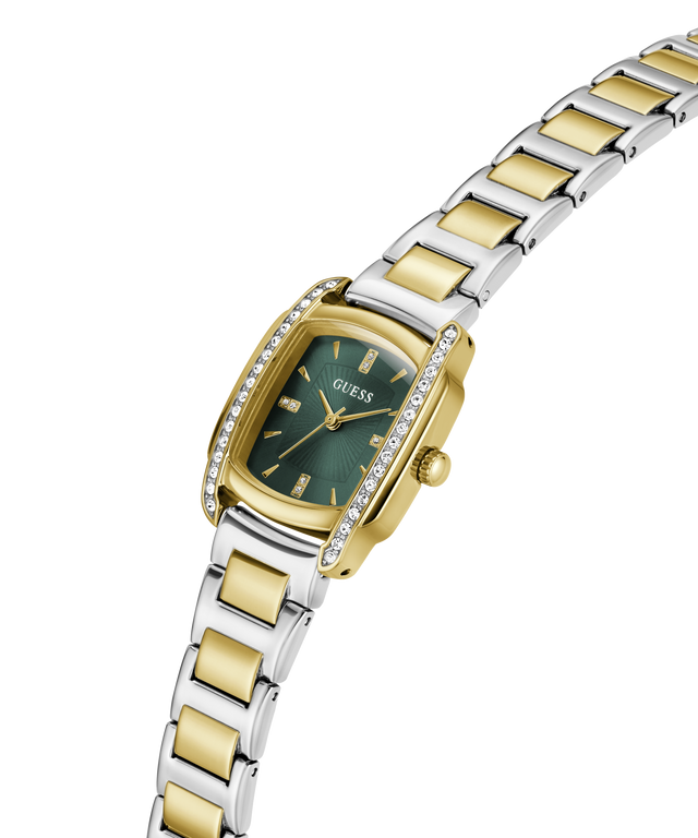 A two-tone yellow gold and silver stainless steel watch by Guess, featuring a green dial, a bezel set with small clear crystals, and a matching two-tone link bracelet, shown on a plain white background. lifestyle