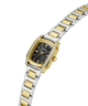 A two-tone yellow gold and silver stainless steel watch by Guess, featuring a green dial, a bezel set with small clear crystals, and a matching two-tone link bracelet, shown on a plain white background. lifestyle