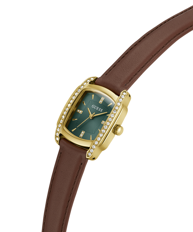 A Guess wristwatch with a gold-tone case, diamond-accented bezel, and a dark green dial, paired with a brown leather strap on a plain white background. lifestyle