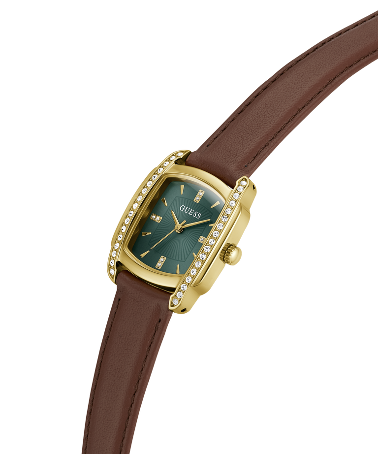 A Guess wristwatch with a gold-tone case, diamond-accented bezel, and a dark green dial, paired with a brown leather strap on a plain white background. lifestyle