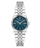 A Guess women's analog watch with a silver stainless steel link bracelet, a fluted bezel, and a dark teal blue dial with a date window.