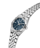 A Guess women's analog watch with a silver stainless steel link bracelet, a fluted bezel, and a dark blue dial with silver-tone hands and markers. lifestyle