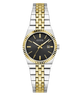 A Guess women's two-tone watch with a silver and gold metal link bracelet, a black dial, and a fluted gold bezel, shown on a plain white background.