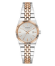 A Guess women's two-tone stainless steel and rose gold watch with a white dial, fluted bezel, and integrated link bracelet, shown against a plain white background.
