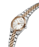 A GUESS women's watch featuring a two-tone silver and rose gold metal bracelet, a fluted rose gold bezel, and a white dial with a date window. lifestyle