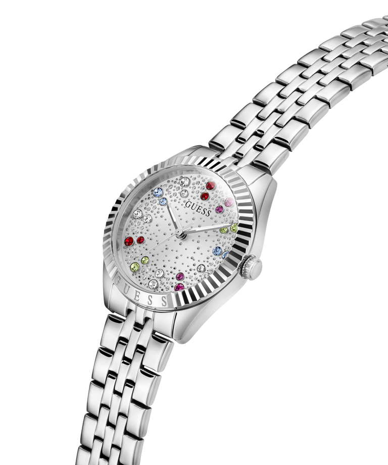 A Guess women's stainless steel watch with a silver-tone metal link bracelet, featuring a white dial embellished with tiny clear stones and colorful crystal hour markers. lifestyle