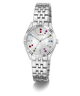 A silver-tone stainless steel wristwatch by Guess with a fluted bezel, a silver-tone link bracelet, and a white dial decorated with tiny floral patterns and colorful crystal hour markers.