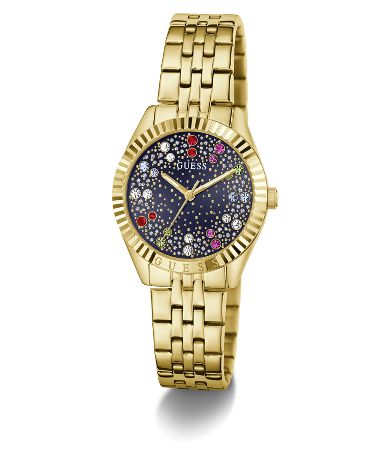 Gold-tone Guess wristwatch with a fluted bezel, gold-tone metal link bracelet, and a dark blue dial decorated with colorful crystal-like star accents.