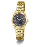 Gold-tone Guess wristwatch with a fluted bezel, gold-tone metal link bracelet, and a dark blue dial decorated with colorful crystal-like star accents.