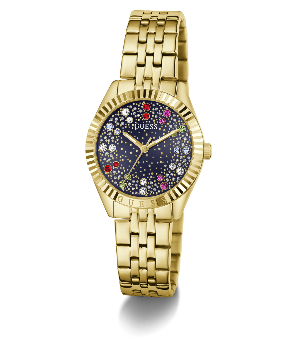 Gold-tone Guess wristwatch with a fluted bezel, gold-tone metal link bracelet, and a dark blue dial decorated with colorful crystal-like star accents.