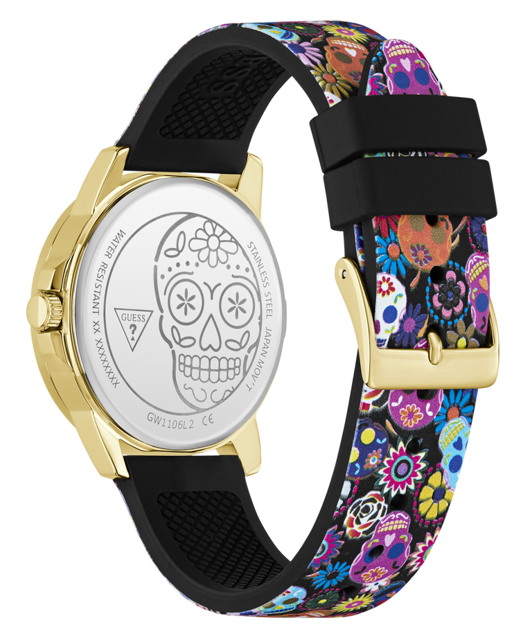 A Guesst watch shown from the back, featuring a gold-tone case, a silver-tone back with a sugar skull engraving, and a black silicone strap with a vibrant multicolor floral and sugar skull pattern.