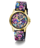 A GUESS women's watch featuring a gold-tone case and a black strap decorated with a colorful Day of the Dead sugar skull and floral pattern, set against a plain white background.
