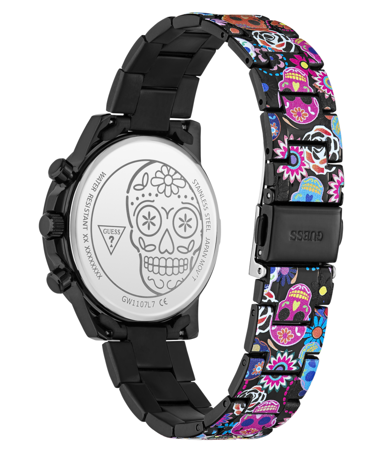 A Guess women's watch with a black stainless steel case and a colorful Day of the Dead patterned link band, shown from the back to reveal the engraved silver case back with a sugar skull design.
