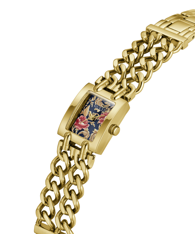 A gold-tone metal watch with a chunky curb-link bracelet and a rectangular face featuring a floral and dragon design on a navy blue background. lifestyle