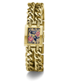 A gold-tone GUESS watch with a thick chain-link bracelet and a rectangular face featuring a navy blue background with pink and gold floral details.