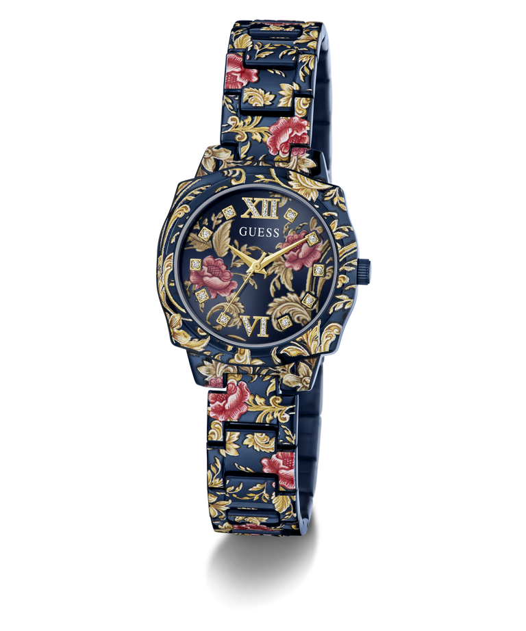 A GUESS women's watch featuring a dark blue metal case and link bracelet decorated with a gold floral pattern and red rose accents, set against a plain white background.