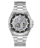 A Guess automatic skeleton watch with a silver stainless steel case and link bracelet, featuring a black dial with a visible mechanical movement through the case.