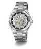 A GUESS men's skeleton watch with a silver stainless steel case and bracelet, featuring a black dial with a skeletonized openwork design that reveals the inner mechanical movement.
