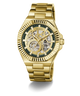 Gold-tone GUESS wristwatch with a skeleton dial, featuring a gold metal link bracelet, ridged bezel, and dark green inner dial details.