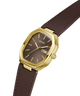 A Guess wristwatch with an octagonal gold-tone case, a dark brown dial, and a matching brown leather strap, shown on a plain white background. lifestyle