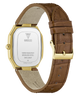 The back of a Guess wristwatch with a gold-tone case and a brown textured leather strap, shown on a clean white background.