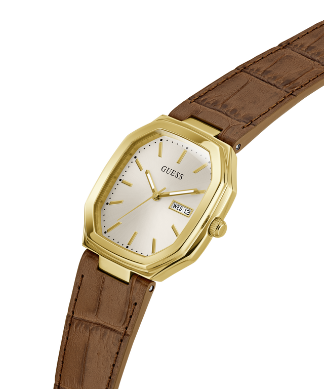 A Guess wristwatch with a gold-tone octagonal case, cream-colored dial, and a brown leather strap, shown on a plain white background. lifestyle
