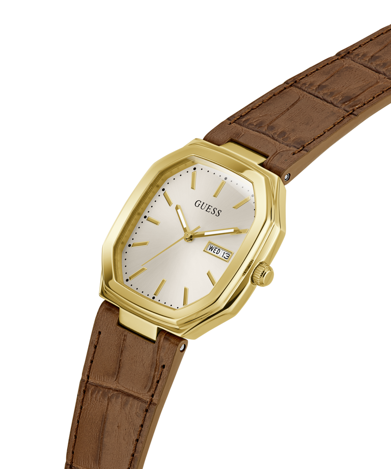 A Guess wristwatch with a gold-tone octagonal case, cream-colored dial, and a brown leather strap, shown on a plain white background. lifestyle