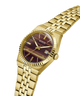 Gold-tone Guess wristwatch with a brown striped dial and a matching gold-tone metal link bracelet, shown on a plain white background. lifestyle