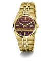 A gold-tone stainless steel wrist watch by Guess, featuring a fluted bezel, a gold-tone link bracelet, and a dark burgundy dial with gold-tone hour markers and hands.