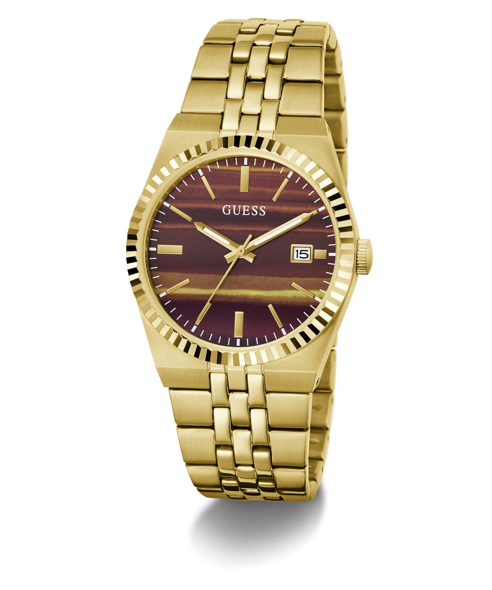 A gold-tone stainless steel wrist watch by Guess, featuring a fluted bezel, a gold-tone link bracelet, and a dark burgundy dial with gold-tone hour markers and hands.
