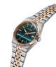 A GUESS men's watch featuring a two-tone silver and rose gold stainless steel and bracelet, with a distinctive teal-blue marbled dial and a fluted rose gold bezel. lifestyle