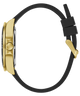 A side profile view of a smartwatch with a brushed gold case, a black silicone strap, and a gold magnetic clasp, shown on a solid white background.