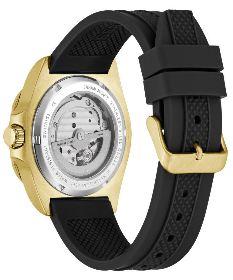A close-up of a wristwatch showing the back case and strap. The watch has a gold-tone case with a transparent back revealing the mechanical movement, paired with a black textured silicone strap and a gold-tone buckle.