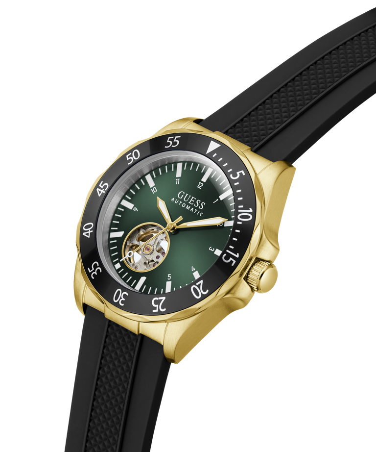 A Guess Automatic watch with a gold-tone case, black bezel, green dial, and black textured strap, shown on a clean white background. lifestyle