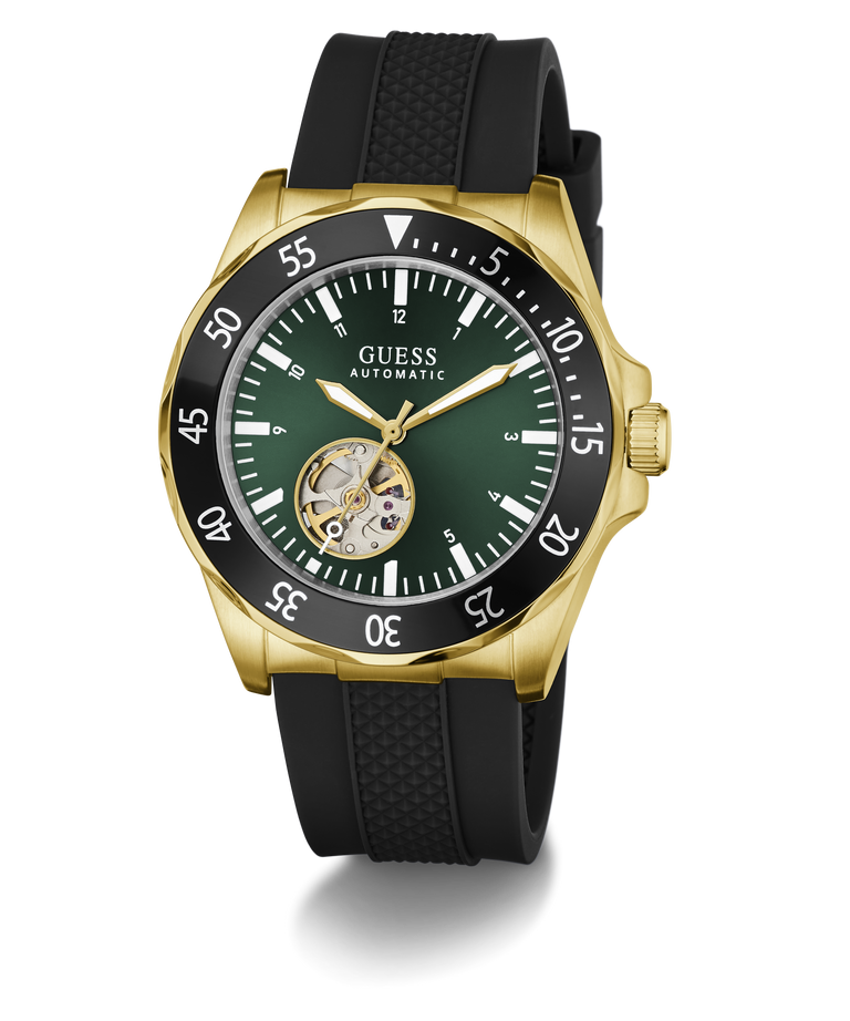 A GUESS Automatic watch with a gold-tone case, black textured strap, and a dark green dial featuring a skeletonized sub-dial showing the inner movement.