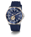 A GUESS Automatic watch with a blue dial, blue textured silicone strap, and a silver-tone stainless steel case accented with a gold-tone case bezel and skeletonized inner dial.