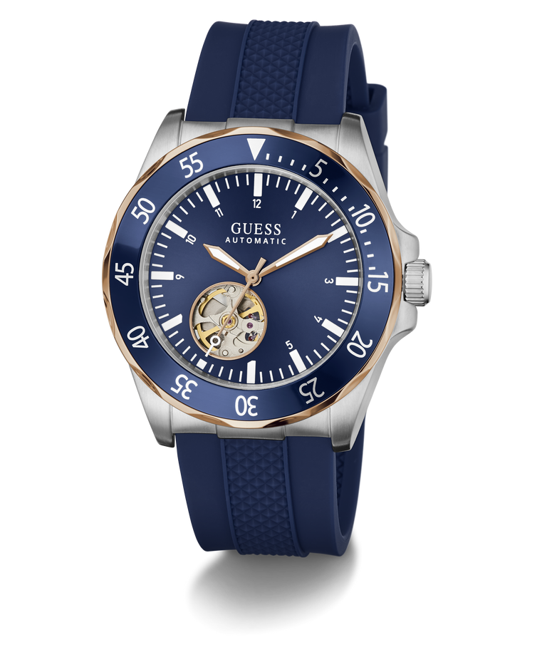 A GUESS Automatic watch with a blue dial, blue textured silicone strap, and a silver-tone stainless steel case accented with a gold-tone case bezel and skeletonized inner dial.