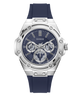 A Guess men's watch featuring a silver stainless steel case with a distinctive screw-decorated bezel, a dark blue dial with three sub-dials, and a dark blue silicone strap, shown against a plain white background.