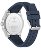 The back view of a Guess watch with a silver stainless steel case and a dark navy blue silicone strap, shown on a solid white background.