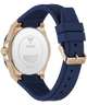 A close-up rear view of a Guess watch with a navy blue silicone strap and a rose gold case, showing the brushed stainless steel back case.